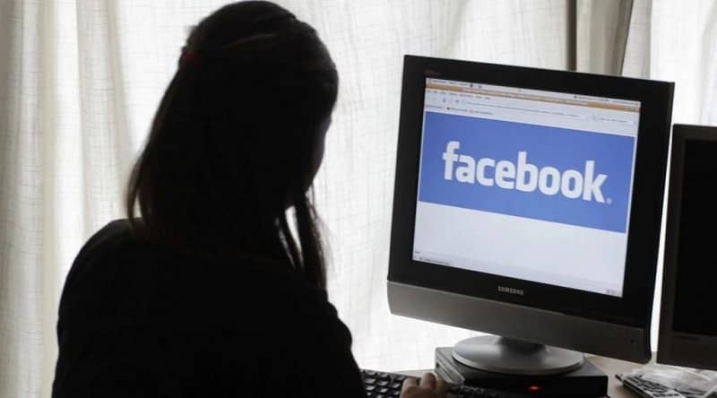 mujer manejando computadora facebook